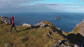 A hiker enjoys the stunning view from Måtinden, overlooking the ocean and islands - Powered by Shutterstock - Get 15% off with code: PIKWIZARD15