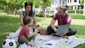 Mixed race little boy enjoy playing and painting while parent taking him to picnic in the park. Father using the laptop, working on the weekend.
 - Powered by Shutterstock - Get 15% off with code: PIKWIZARD15
