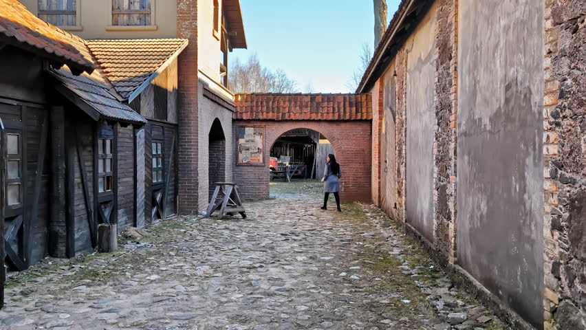 Travelling shot of woman walking in a old town, slow motion