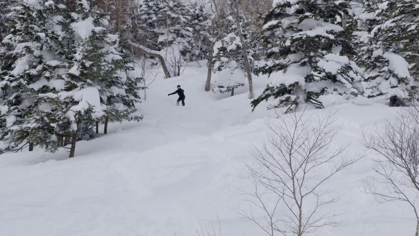 Freeride Snowboarder in Nagano – A snowboarder wearing a helmet and goggles prepares for a freeride descent.