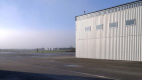 Revealing Shot of Hangars at the Airfield on a Misty, Sunny Morning - Powered by Shutterstock - Get 15% off with code: PIKWIZARD15