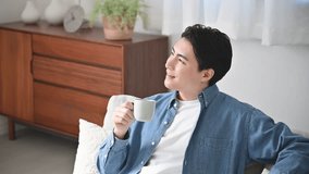 Relaxed young man drinking coffee in the living room - Powered by Shutterstock - Get 15% off with code: PIKWIZARD15