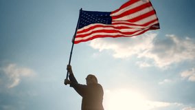 Happy young man standing proudly with holding and raising US flag against blue sky with sunlight background, proud American holding the United states flag, USA flag waving celebration concept.
 - Powered by Shutterstock - Get 15% off with code: PIKWIZARD15