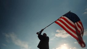 Happy young man standing proudly with waving USA flag against beautiful blue sky with sunlight background while standing on the mountain, United States flag waving celebration concept.
 - Powered by Shutterstock - Get 15% off with code: PIKWIZARD15