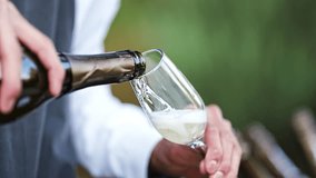 close-up. the waiter's hands with a glass and a bottle of champagne. Sparkling wine is poured into a glass. A traditional drink for special events. - Powered by Shutterstock - Get 15% off with code: PIKWIZARD15