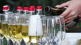close-up. the waiter's hands with glasses and a bottle of champagne. Sparkling wine is poured into a glass. A traditional drink for special events. - Powered by Shutterstock - Get 15% off with code: PIKWIZARD15