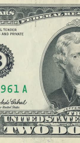 Detailed engraved portrait on American two-dollar bill filmed in smooth horizontal pan motion, showcasing classical banknote design and intricate engraving details in high resolution