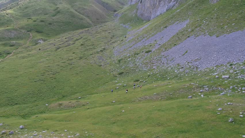 People Hiking on a Wild Mountain Trail in a Green Meadow