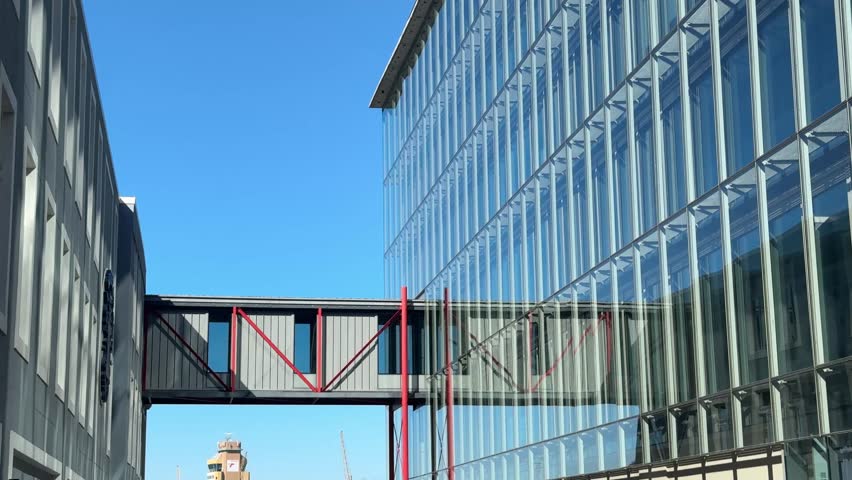 A pristine glass building with a mini bridge across it, located in the waterfront precinct of Cape Town, South Africa.