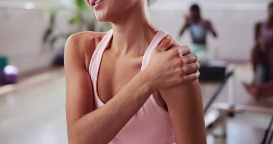 Woman, hands and shoulder pain with injury at gym for muscle tension, sprain or pressure at health club. Closeup, female person or athlete with sore joint, ache or inflammation for fitness strain