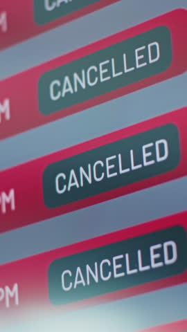 Airport Terminal: Close Up of Digital Arrival and Departure Information Display Showing Flight Data For Travelers. Cancelled Flights Due to Bad Weather Conditions or Terrorist Attack. Vertical Shot.