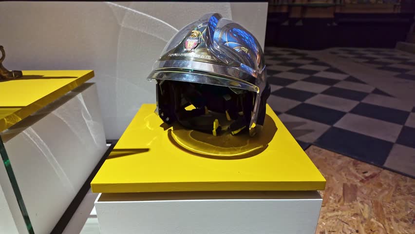 Firefighter helmet displayed in exhibit inside Notre-Dame de Paris, honoring firemen, France. Close-up