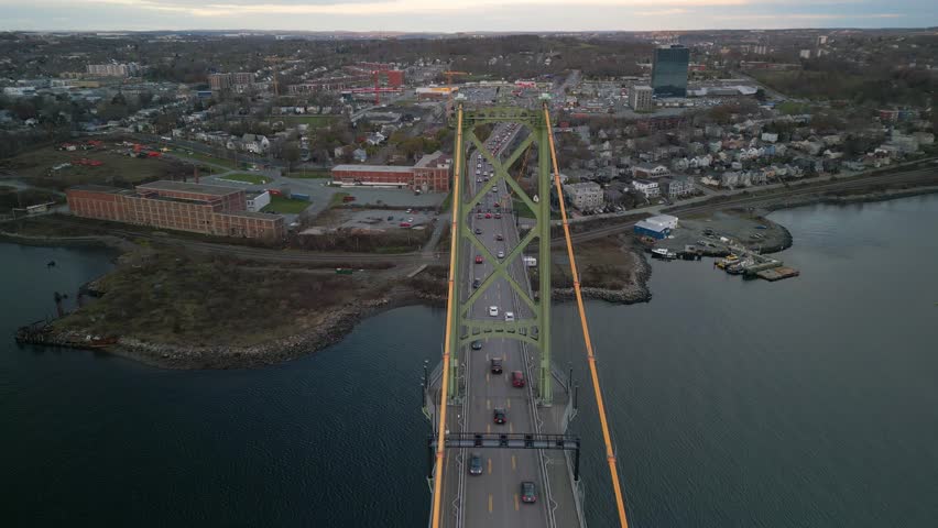 Aerial Footage Of The Historic Highway Bridge Connecting Halifax And Dartmouth, Nova Scotia. Cars Flow Across The Bridge, Showing The Vital Urban Link Between The Two Canadian Cities.