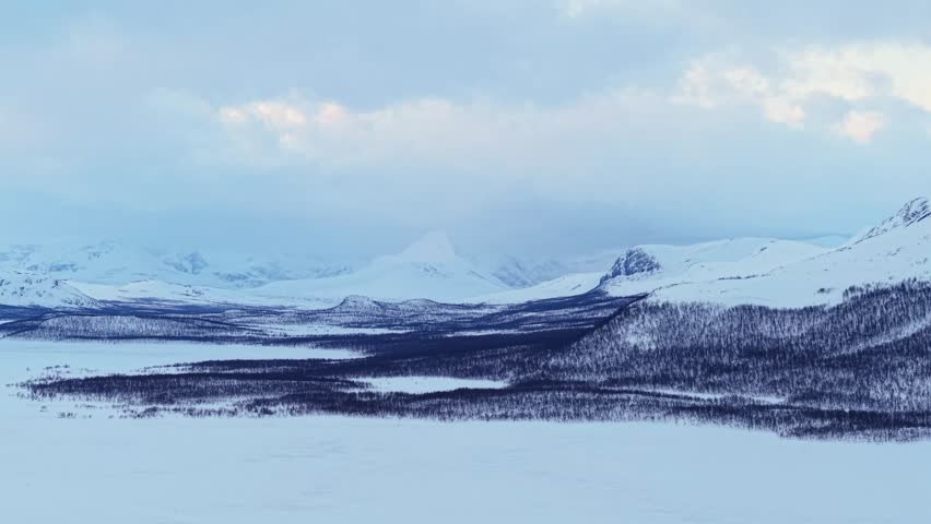 Snowy kilpisjärvi in finland, featuring mountains and frozen landscape, aerial view