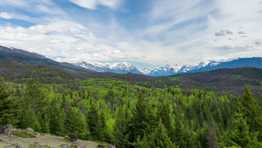 Jasper National Park in summer, Alberta, Canada. Panorama view of forest valley and mountain range. Time-lapse photography.