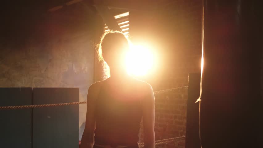 Woman fighter with boxing gloves standing on boxing ring celebrating victory. Woman boxing champion showing raising hands up. Strong powerful girl on boxing ring arena. Competition champion winner