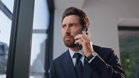 Worried ceo talking mobile phone sitting cozy cafeteria table alone zoom out. Serious businessman discussing work in cellphone call at coffee break. Concerned cafe visitor in suit speaking emotionally - Powered by Shutterstock - Get 15% off with code: PIKWIZARD15