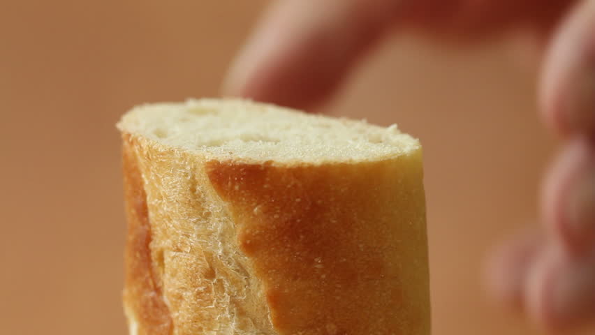 Detail of slicing a baguette with a knife.