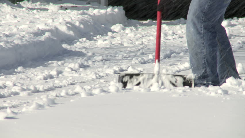 Close up of a snow shovel being used to dig snow.