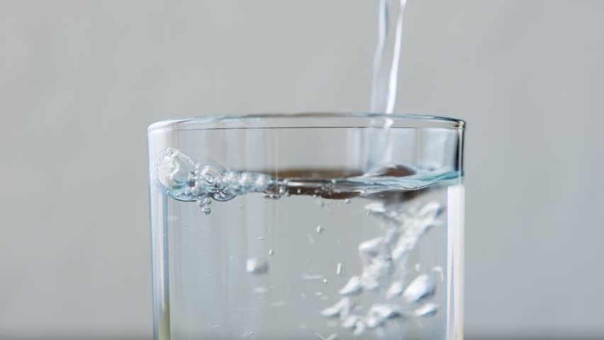 Drinking water pouring into glass close-up.