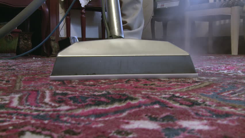 Cleaning a carpet with a steam wand, close up from the front.