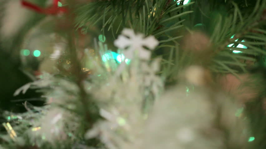 Dolly shot of decorations on a Christmas Tree, coming to rest on a silver
