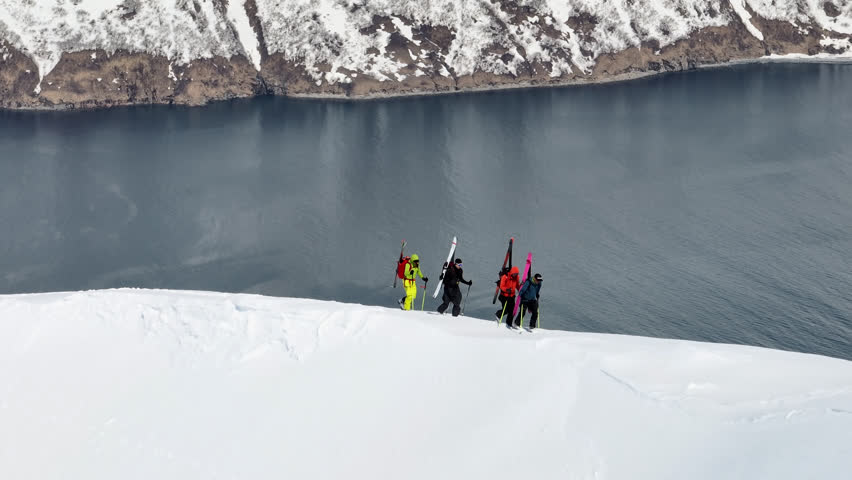 Group of mountain tourists climb snowy mountains in winter, aerial view