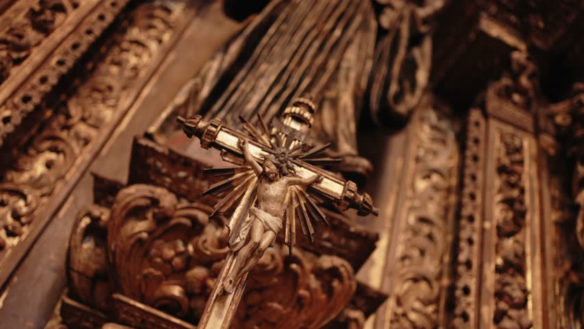 Intricate golden crucifix with radiant details set in a richly decorated baroque church