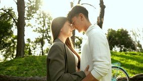 Romantic couple sharing intimate embrace amid sunlit greenery, embodying tender connection and peaceful moment of togetherness in scenic park setting - Powered by Shutterstock - Get 15% off with code: PIKWIZARD15