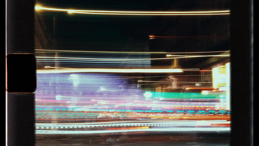City lights streaking by at night from moving vehicle
