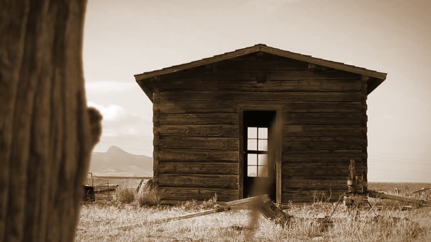 Dolly move towards an old cabin in the wild west, near Cody, Wyoming. Clip
