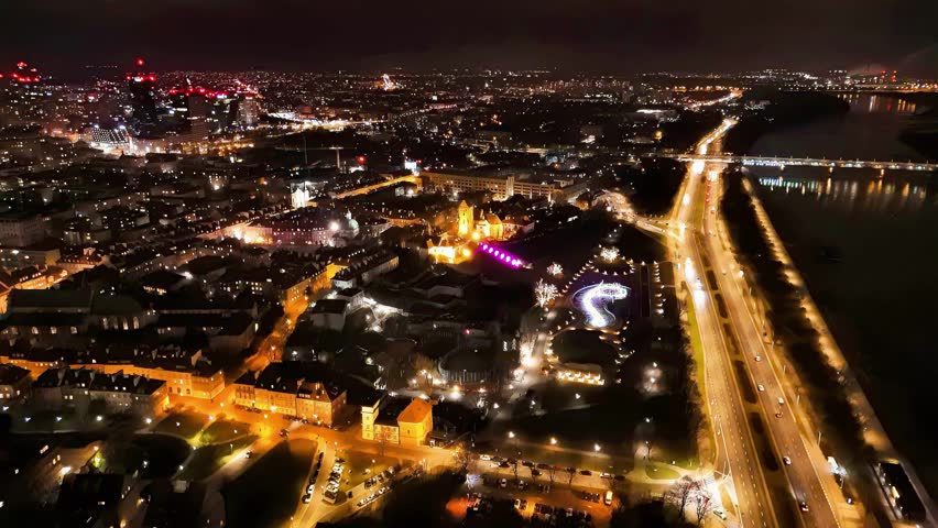 Descending drone shot of Warsaw center in the night with Vistula river