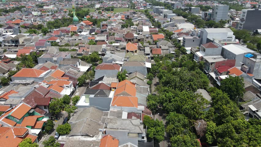 Aerial drone view of cityscape and urban neighborhood, residential district with buildings and streets in Surabaya, East Java, Indonesia.