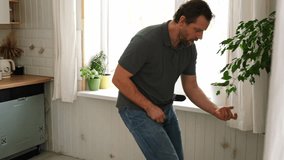 Handsome bearded man dance, have fun at home listens song, moves to music, feels overjoyed, celebrate good news, relish carefree life looks happy. Young adult male twirls, grooves. Brutal man dancer - Powered by Shutterstock - Get 15% off with code: PIKWIZARD15