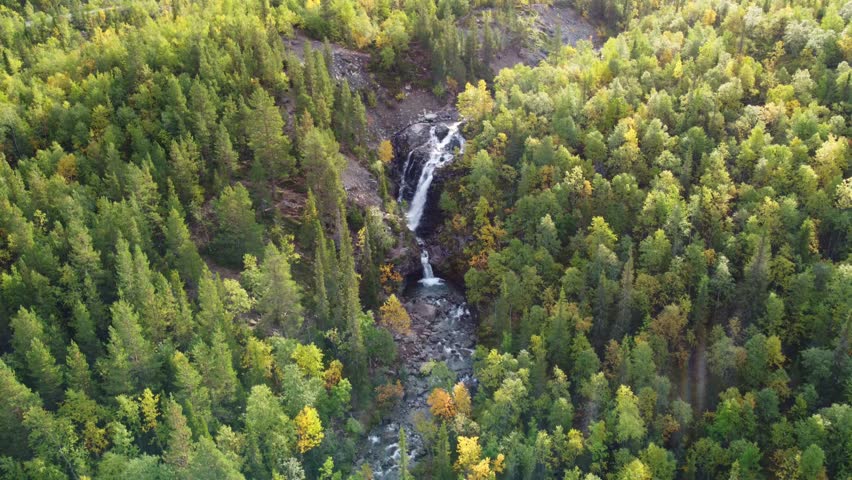 A beautiful waterfall in the autumn mountains beyond the Arctic Circle in the north, in Khibiny, Murmansk region. Panoramic view of a beautiful waterfall in the mountains in autumn, Kola Peninsula 4К