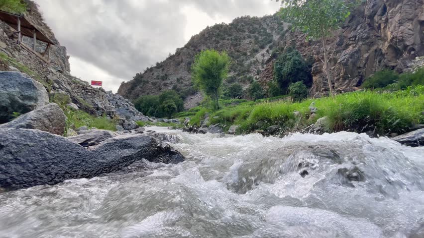 Whitewater flowing over rocks in a picturesque valley in the Khyber Pakhtunkhwa region of Pakistan. low angle