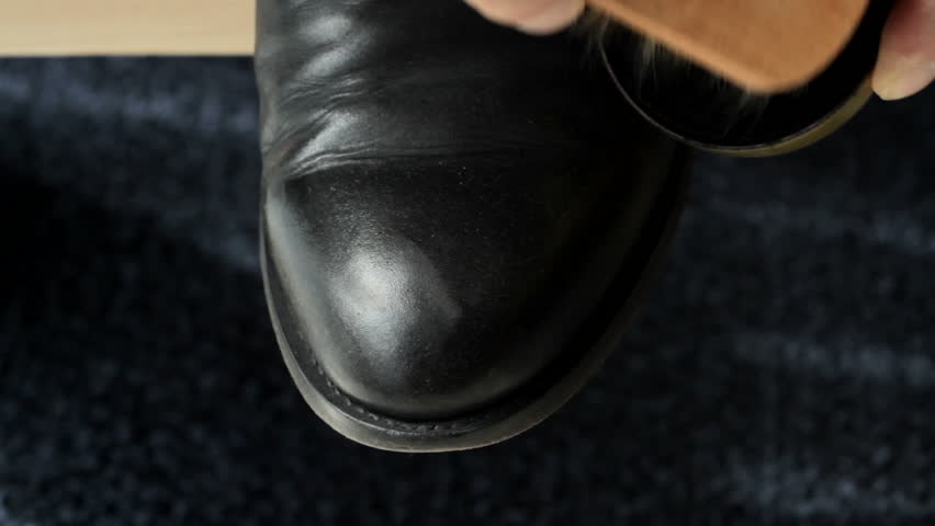 Detail of a cowboy boot being waxed and shined. Middle part of clip is sped up.