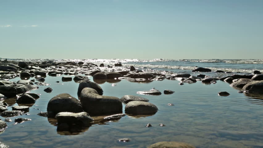 Rocky shoreline on Lake Michigan, USA. Pebble is thrown into water, making a