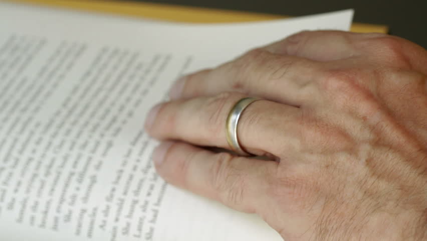 Close shot of hand as someone reads a book. Recorded with macro lens and very