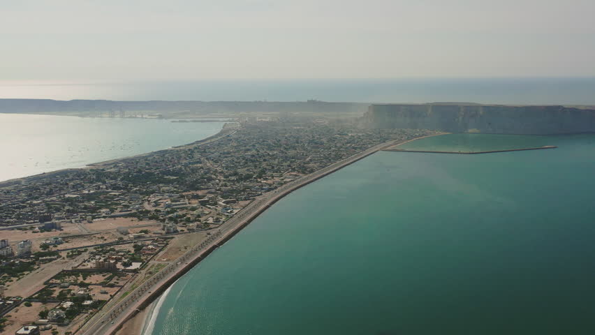 A breathtaking aerial view of Gwadar, Balochistan, Pakistan, showcasing the city's stunning coastline, modern port, and rugged mountainous landscape.