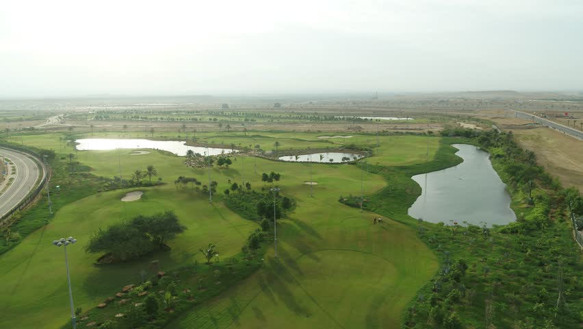 A golf course is a vast, scenic landscape designed for the game of golf, featuring lush green fairways, sand bunkers, water hazards, and manicured lawns. The contrast between day and night brings out 