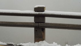 A close-up of a concrete barrier post with snow accumulating on top. The snow contrasts with the rough texture of the post, and the background is filled with mist, adding a sense of winter stillness. - Powered by Shutterstock - Get 15% off with code: PIKWIZARD15
