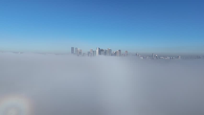 Breathtaking aerial view of Canary Wharf, London, as skyscrapers pierce through a mesmerizing cloud inversion, offering a dramatic, cinematic skyline experience.