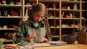 Angry upset frustrated Caucasian little girl female child schoolgirl kid artist potter rage throwing mud clay material failure trouble lack of creativity problem mental burnout indoors pottery class - Powered by Shutterstock - Get 15% off with code: PIKWIZARD15