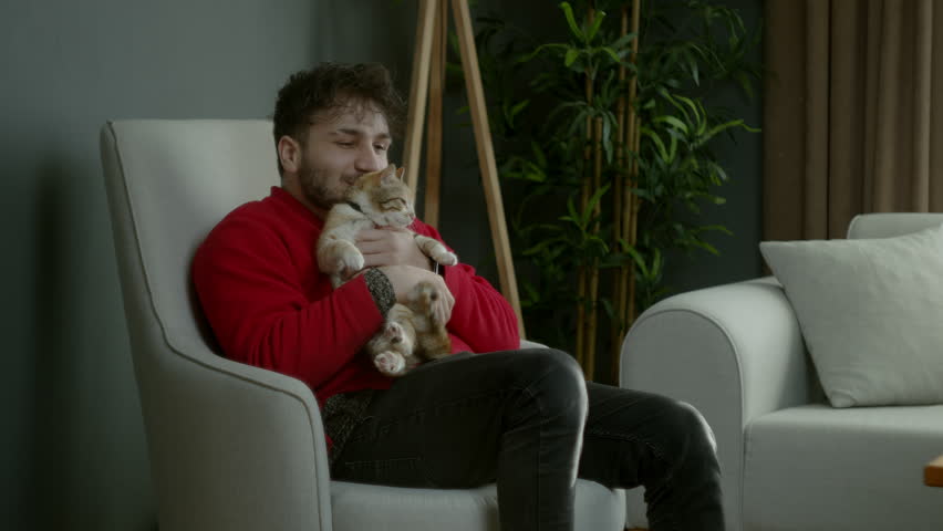 Young Man Cuddling His Cat in a Cozy Home