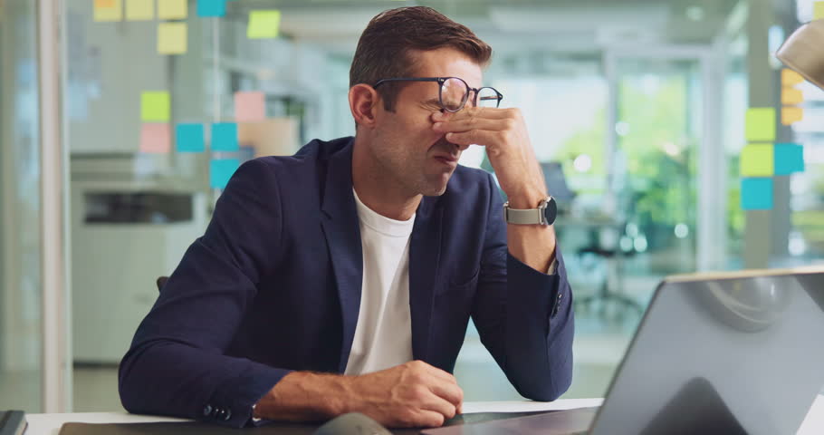 Glasses, headache and businessman in office with fatigue, brain fog or eye strain in morning. Laptop, tired and creative magazine editor with stress tension migraine for deadline with exhaustion.