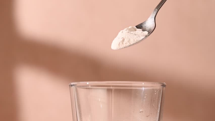 Protein powder, collagen powder pouring in a glass. Food supplement, fitness sport, health and nutrition.