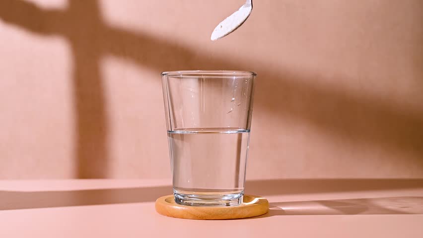 Protein powder, collagen powder pouring in a glass. Food supplement, fitness sport, health and nutrition.