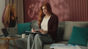 Caucasian woman architect home interior designer decorator girl female businesswoman homeowner on couch sofa choosing house design color trend creative work in apartment writing project at notebook - Powered by Shutterstock - Get 15% off with code: PIKWIZARD15