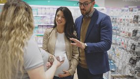 Attractive middle age couple enjoying in buying clothes and appliances for their new baby. Experienced saleswoman trying to help. Expecting baby concept. - Powered by Shutterstock - Get 15% off with code: PIKWIZARD15